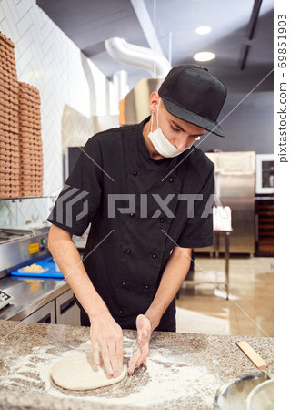 Pizzaiolo with prepearing dough for pizza Pizzaiolo with prepearing dough for pizza 69851903