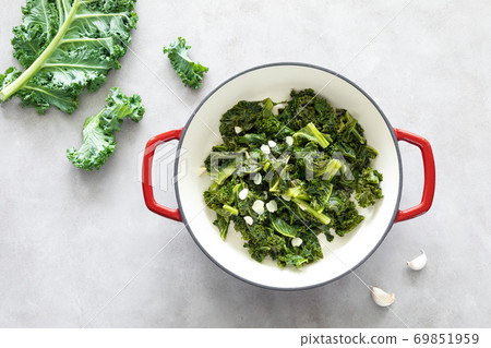 Sauteed kale with garlic in cast iron pan on kitchen table, healthy food concept, superfood 69851959