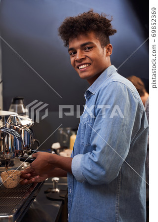 Barista brews coffee for his clients 69852369