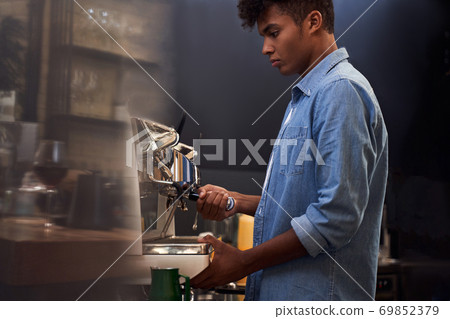 Serious male barista making coffee Serious male barista making coffee 69852379