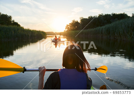 Group of happy tourists walking on kayaks Group of happy tourists walking on kayaks 69853773