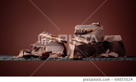 Black chocolate on a brown background. 69855024