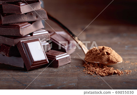 Broken  chocolate pieces and cocoa powder . 69855030