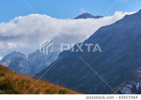 beautiful mountain landscape with autumn alpine meadow and alpine peaks in the clouds beautiful mountain landscape with autumn alpine meadow and alpine peaks in the clouds 69855984