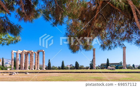 Scenic view of Olympian Zeus temple behind coniferous branches, focus on foreground, Athens, Greece. Scenic view of Olympian Zeus temple behind coniferous branches, focus on foreground, Athens, Greece. 69857112