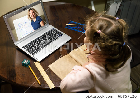 Kid virtual learning with teacher by laptop, tutor teaches preschool child during quarantine due to coronavirus. 69857120