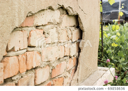 Non technology plaster. Building cracked plaster facade wall with brick Non technology plaster. Building cracked plaster facade wall with brick 69858636