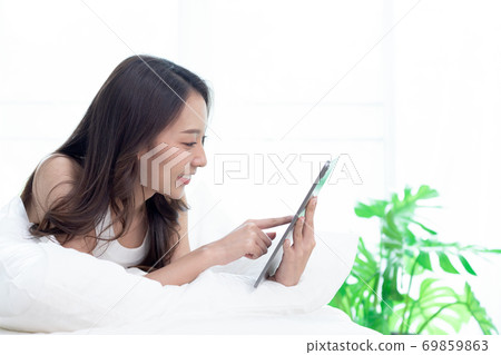 Asian woman shopping online on tablet.Check and working online. Asian woman shopping online on tablet.Check and working online. 69859863