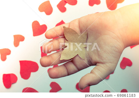 Paper butterfly and paper hearts in hand 69861183