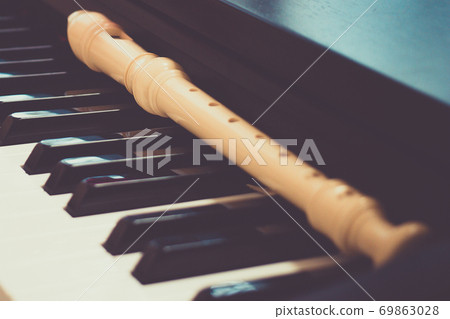 Block flute rest on a piano keyboard. classic music concept 69863028