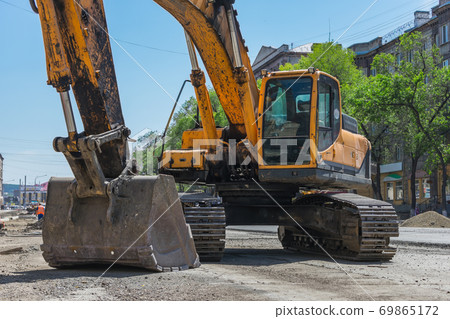 Large excavator for digging trenches during road repair Large excavator for digging trenches during road repair 69865172