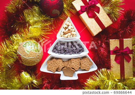 Christmas tree dish with nuts, chocolate and gingerbread cookies Christmas tree dish with nuts, chocolate and gingerbread cookies 69866644