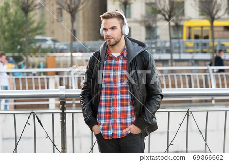 Deliver perfect audio reproduction. Young man wear audio headphones outdoor Deliver perfect audio reproduction. Young man wear audio headphones outdoor 69866662