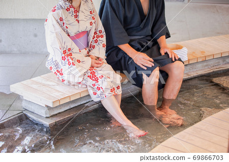Men and women taking a footbath Men and women taking a footbath 69866703