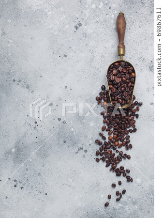 Vintage steel scoop with fresh raw organic coffee beans on light background. 69867611