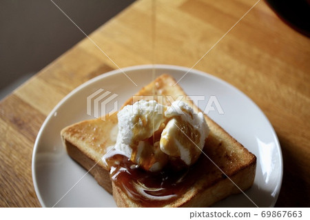 Drizzling maple on buttered toast with vanilla ice cream 69867663