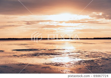 Golden sunset with colorful sky and water in lake reflected in evening Golden sunset with colorful sky and water in lake reflected in evening 69867724