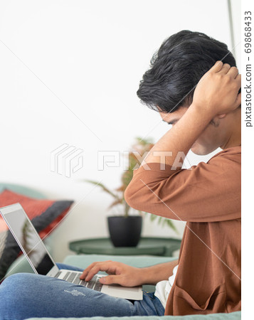 Young Asian man wearing casual clothes and having a headache 69868433