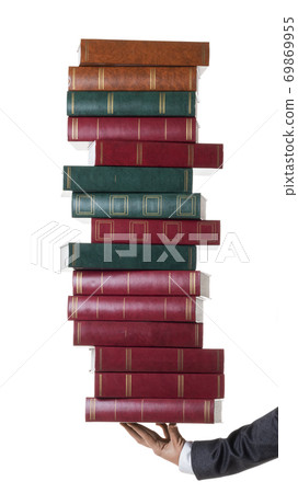 Cropped photo of a hand of a businessperson or lawer holding a stack of books. Cropped photo of a hand of a businessperson or lawer holding a stack of books. 69869955