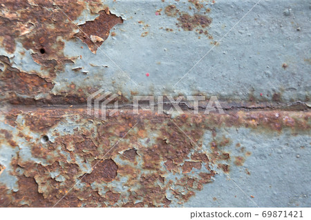Rust has appeared on the blue painted metal wall. Rust has appeared on the blue painted metal wall. 69871421