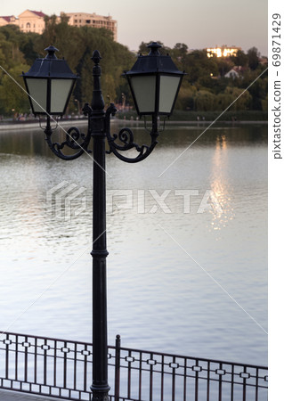 A darkened vintage style street light on the lake. A darkened vintage style street light on the lake. 69871429