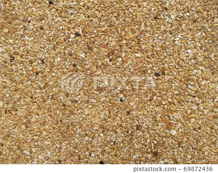 The cement wall consists of small pebbles. 69872436