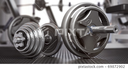 Dumbbell and barbell on the floor of gym. Close up fItness equipment. Sport, fitness and bodybuilding concept background 69872902