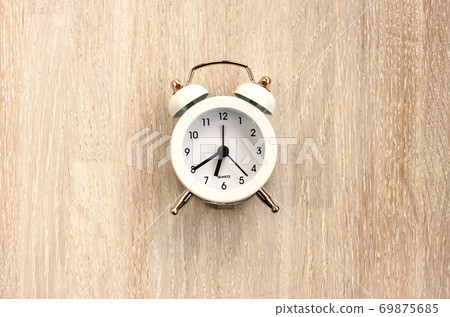 White retro vintage alarm clock on wooden table 69875685