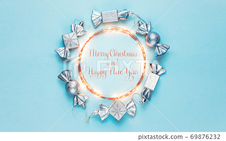 New year 2021. Merry Christmas and Happy Holidays greeting card. Christmas composition. Silver decorations on pastel blue background. Winter, new year concept. Flat lay, top view, copy space New year 2021. Merry Christmas and Happy Holidays greeting card. Christmas composition. Silver decorations on pastel blue background. Winter, new year concept. Flat lay, top view, copy space 69876232