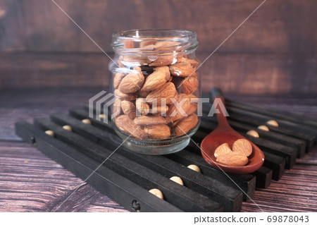 Close up of almond nut in a jar on table Close up of almond nut in a jar on table 69878043