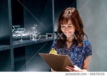購物時在商店裡回答一個問卷的年輕女子 購物時在商店裡回答一個問卷的年輕女子 69878529