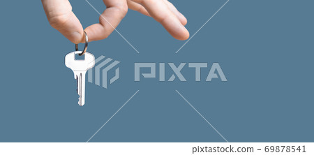 Hand with home key on gray blue background. Hand with home key on gray blue background. 69878541