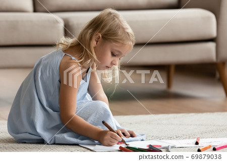 Inspired preschool girl sitting on warm floor drawing imaginary world 69879038