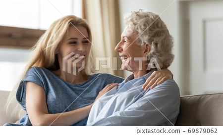 Happy grown up grandchild hugging shoulders of beloved grandmother Happy grown up grandchild hugging shoulders of beloved grandmother 69879062