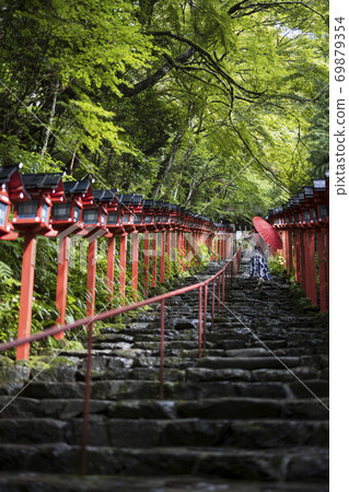 [京都]在基本神社用日本傘在石階上行走的女人 69879354