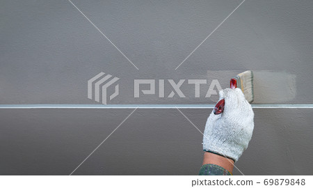 Painting by hand on a cement wall in a straight line Painting by hand on a cement wall in a straight line 69879848
