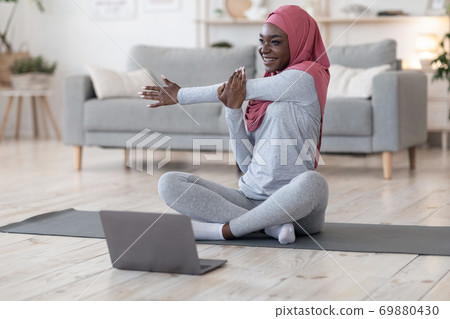 Quarantine Trainings. Sporty African Muslim Woman Exercising In Front Of Laptop 69880430