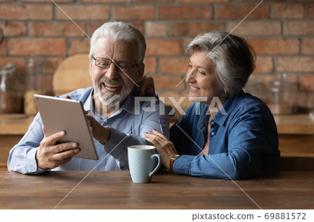 Happy senior man and woman have fun using tablet 69881572