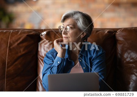 Dreamy elderly woman look in distance thinking Dreamy elderly woman look in distance thinking 69881729