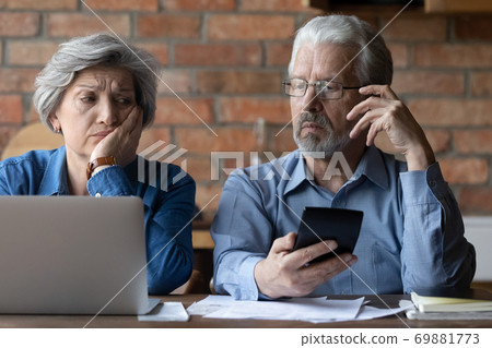 Stressed senior man and woman have problems paying online Stressed senior man and woman have problems paying online 69881773