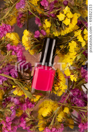 Fuchsia nail polish on natural background of colorfull dry flowers 69882153