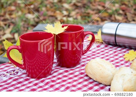 Red cup with yellow leaf, autumn mood background Red cup with yellow leaf, autumn mood background 69882180