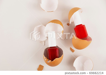 Three red nail polishes in eggshell on light background 69882214