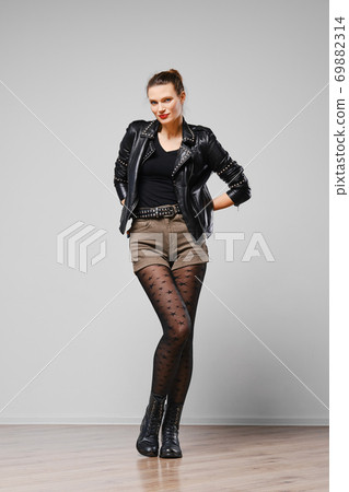 Full length portrait of a woman in leather jacket, shorts and tights with stars Full length portrait of a woman in leather jacket, shorts and tights with stars 69882314