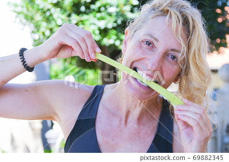 Woman biting celery Woman biting celery 69882345