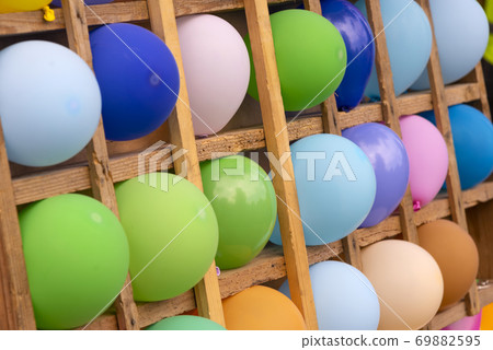 Multicolored balloons in wooden cells. Background from color balloons Multicolored balloons in wooden cells. Background from color balloons 69882595