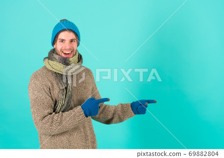 Product for winter sale. Happy guy point fingers at something. Product for winter sale. Happy guy point fingers at something. 69882804