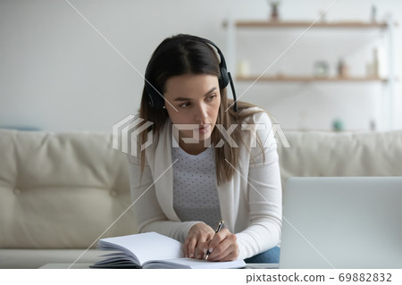 Young woman in headphones study online on laptop 69882832