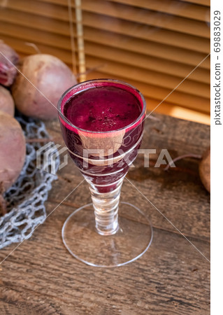 Red beet juice in a glass on a wooden table Red beet juice in a glass on a wooden table 69883029