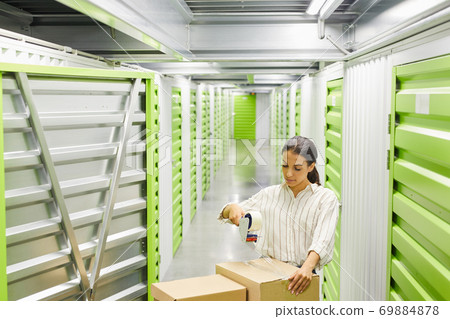 Portrait of Woman Packing Boxes in Storage Unit 69884878